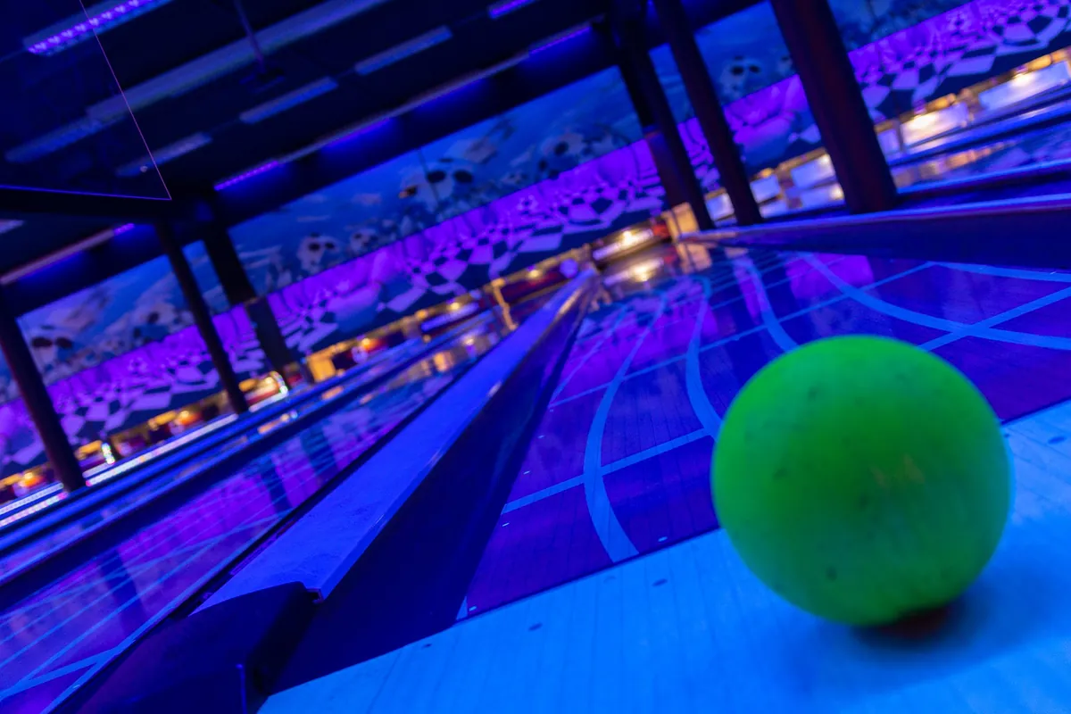 Bowlingkugel auf der unter UV-Licht leuchtenden Bahn