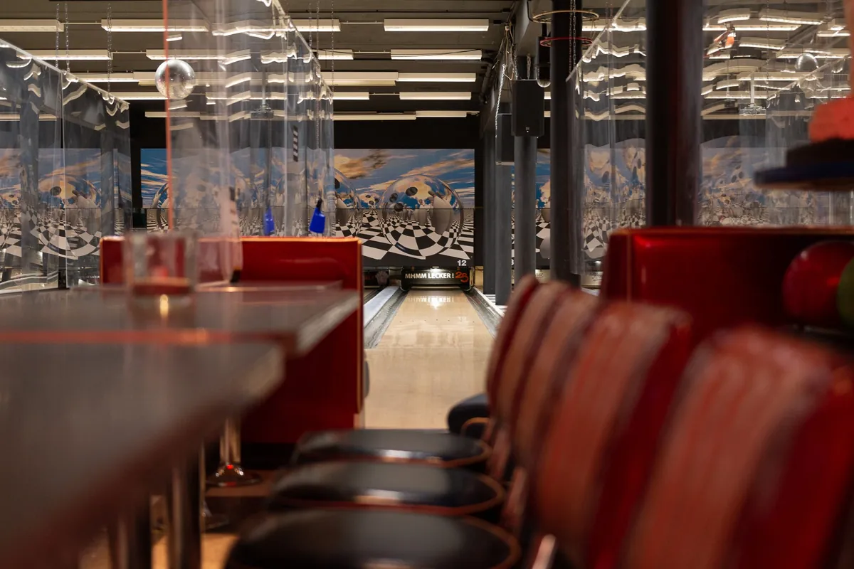 Sitzreihen und Tische an den Bowlingbahnen